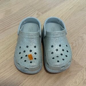 CROCS Kids Silver Glitter Clogs with Orange Charm Accent